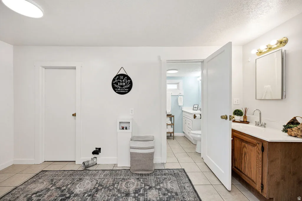 Laundry room with an extra sink and mirror, pantry room to the left, bathroom to the right