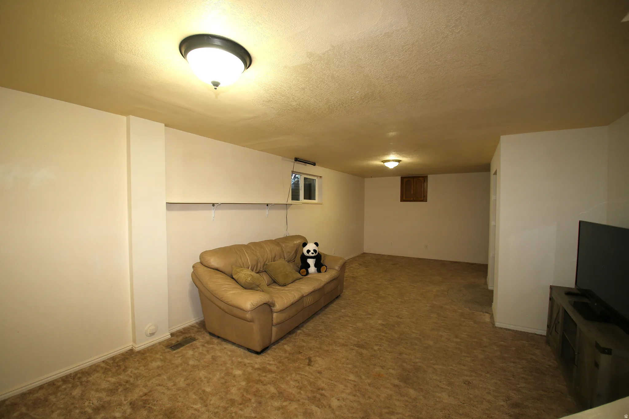 Expansive carpeted room featuring recessed lighting and a window