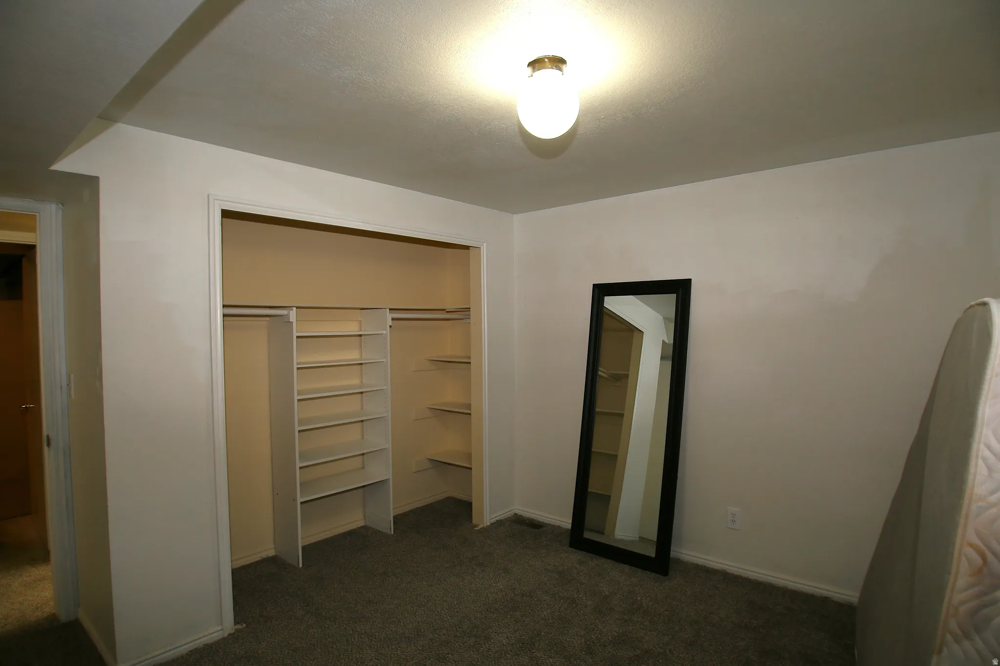 Spacious closet with built-in shelving and hanging rods