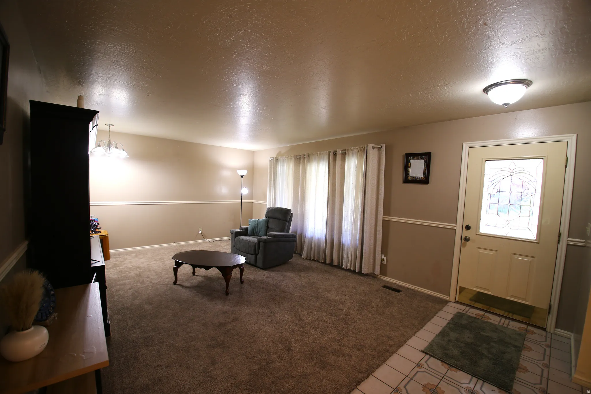 Entryway with a decorative glass-paneled door, tile flooring, and overhead flush-mount lighting