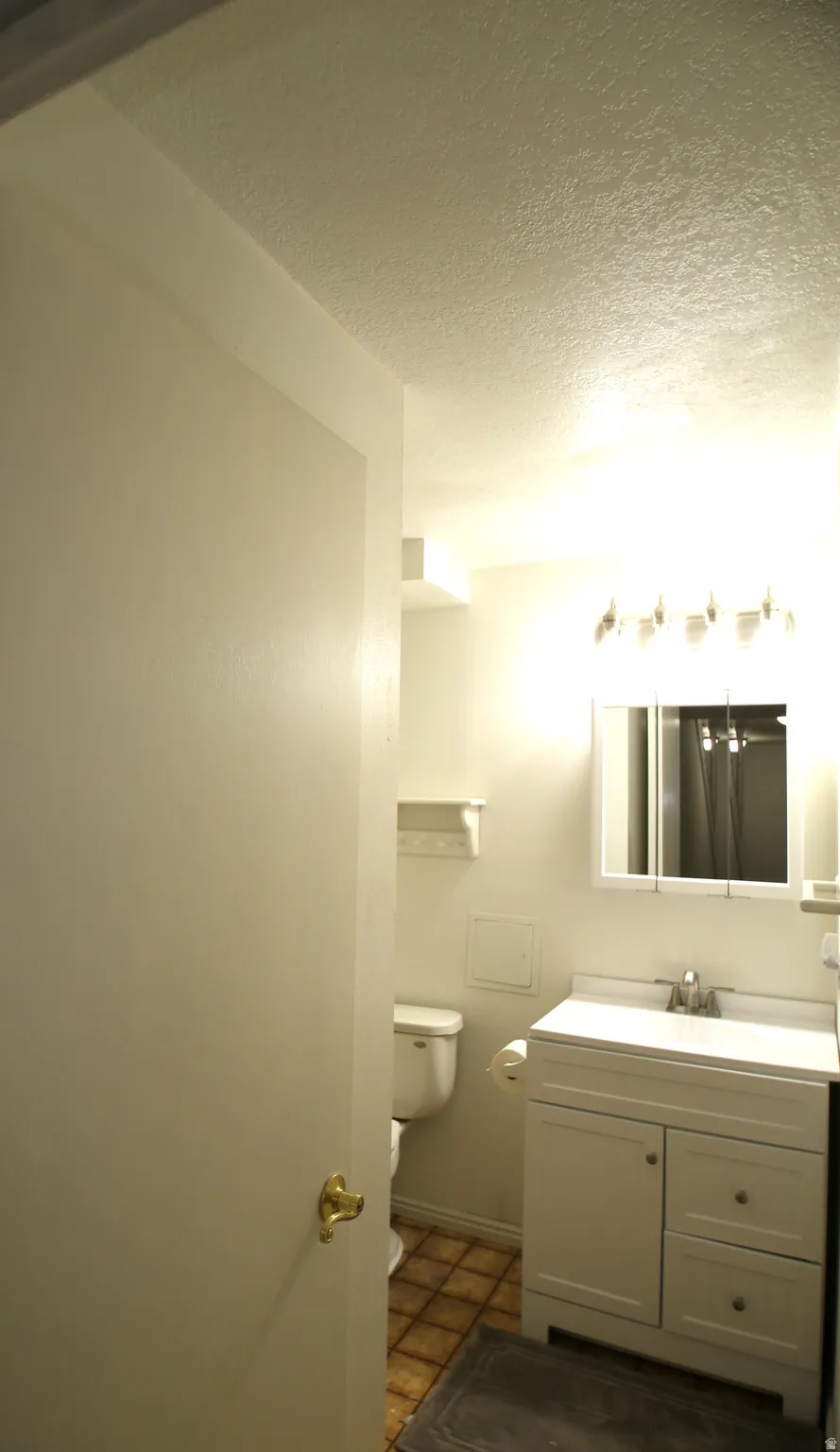 Bathroom featuring a white vanity with integrated sink, chrome faucet, and cabinet storage