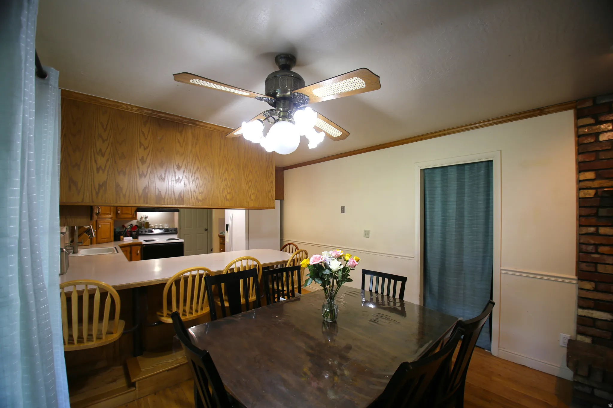 Dining area featuring a wood-finish dining table and a ceiling fan with integrated lighting