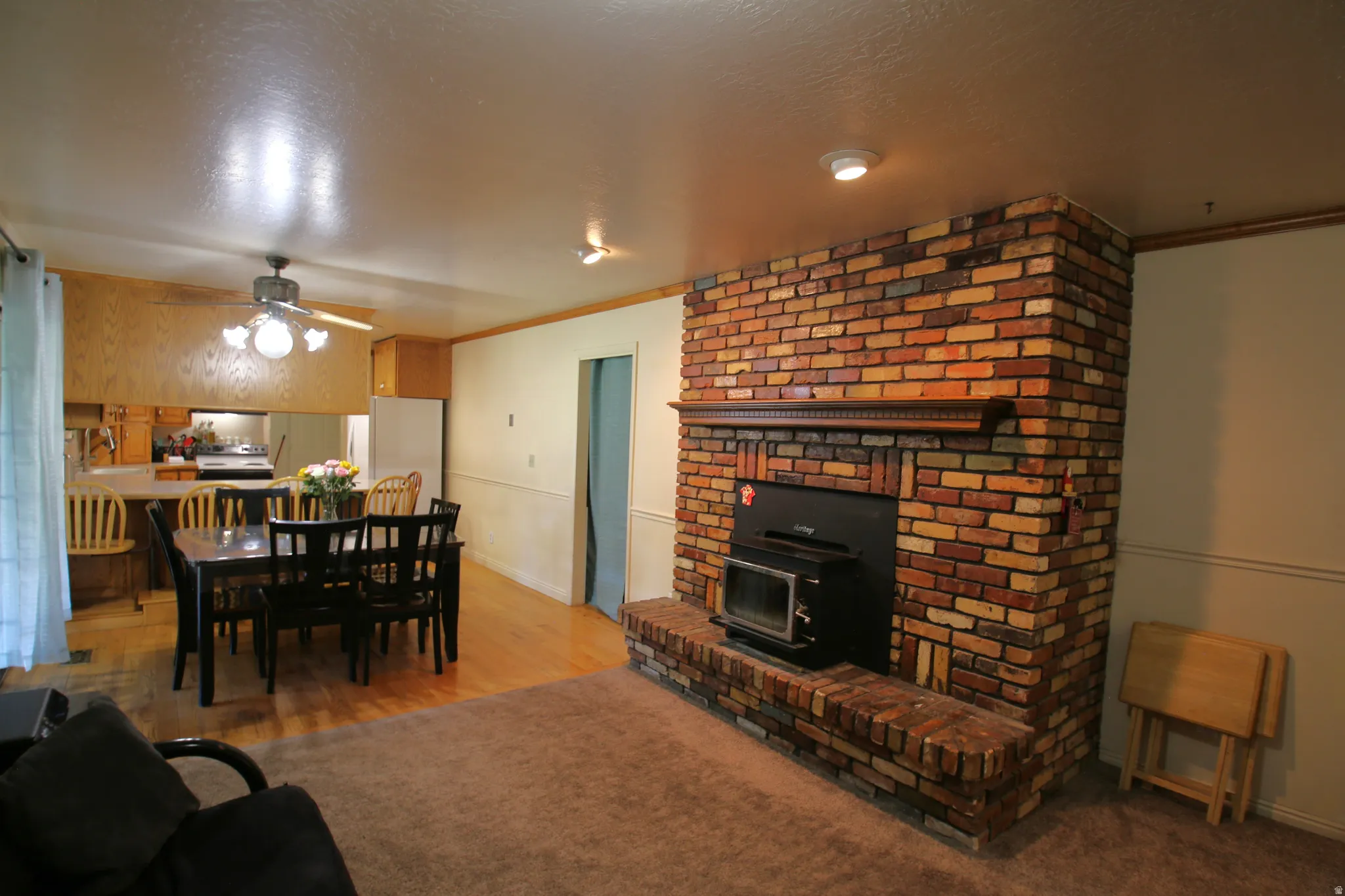 Brick fireplace with a wood-burning insert and a wood mantel