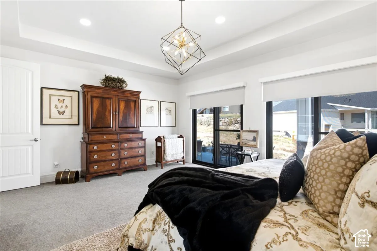 Bedroom featuring a tray ceiling, recessed lighting, and a contemporary geometric chandelier