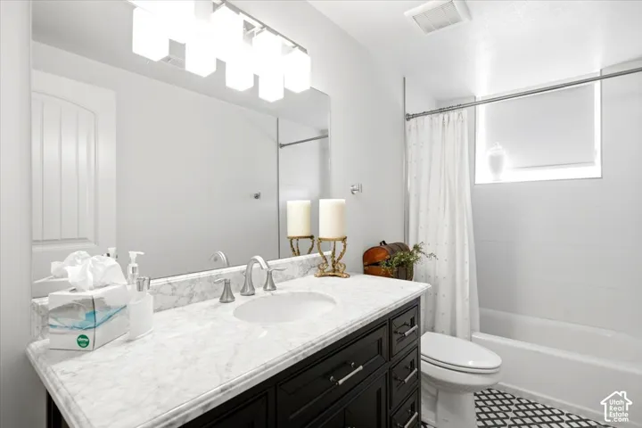 Bathroom with a black vanity featuring a white countertop and an undermount sink