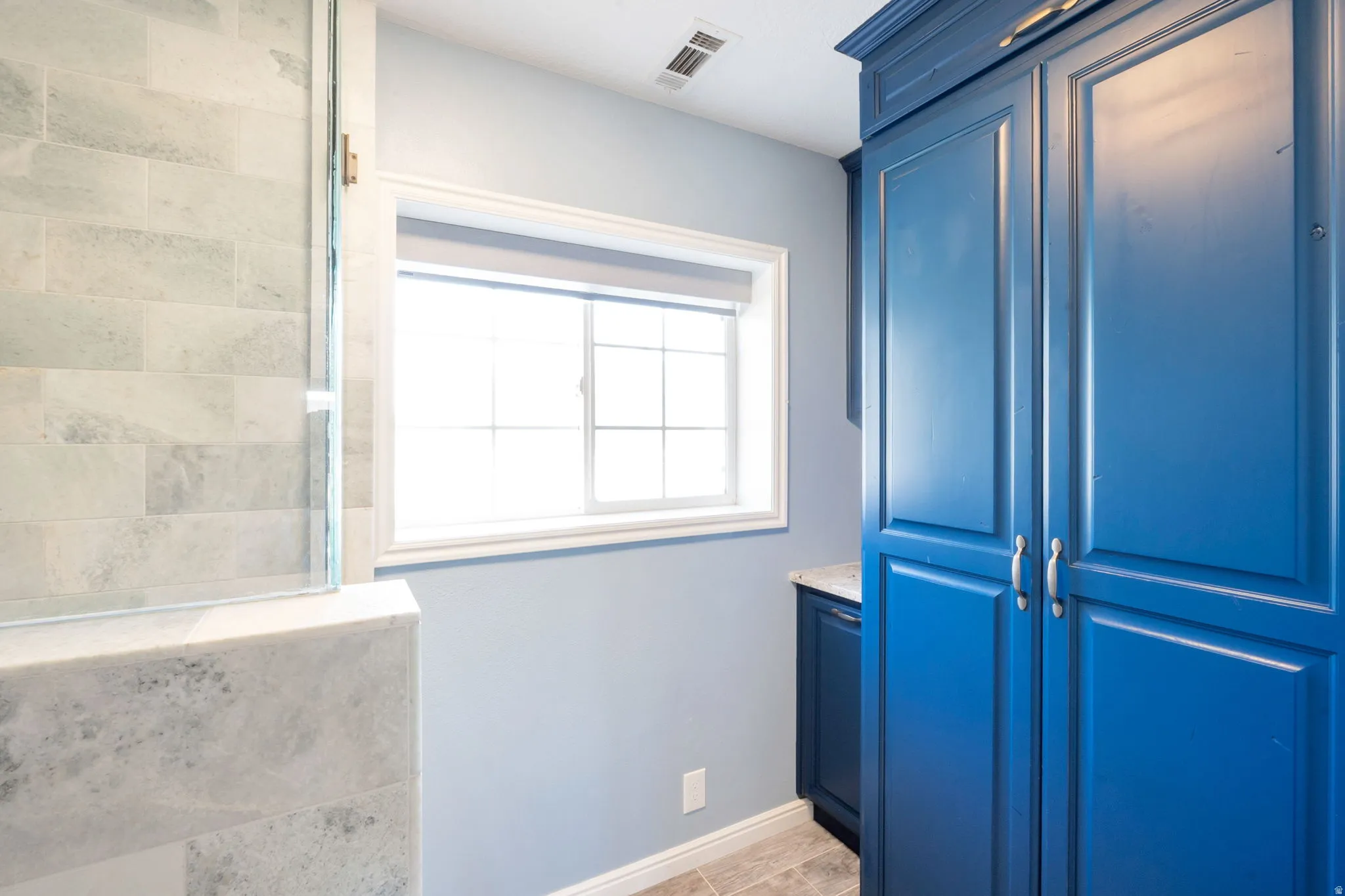 Built-in blue cabinetry with paneled doors and silver hardware
