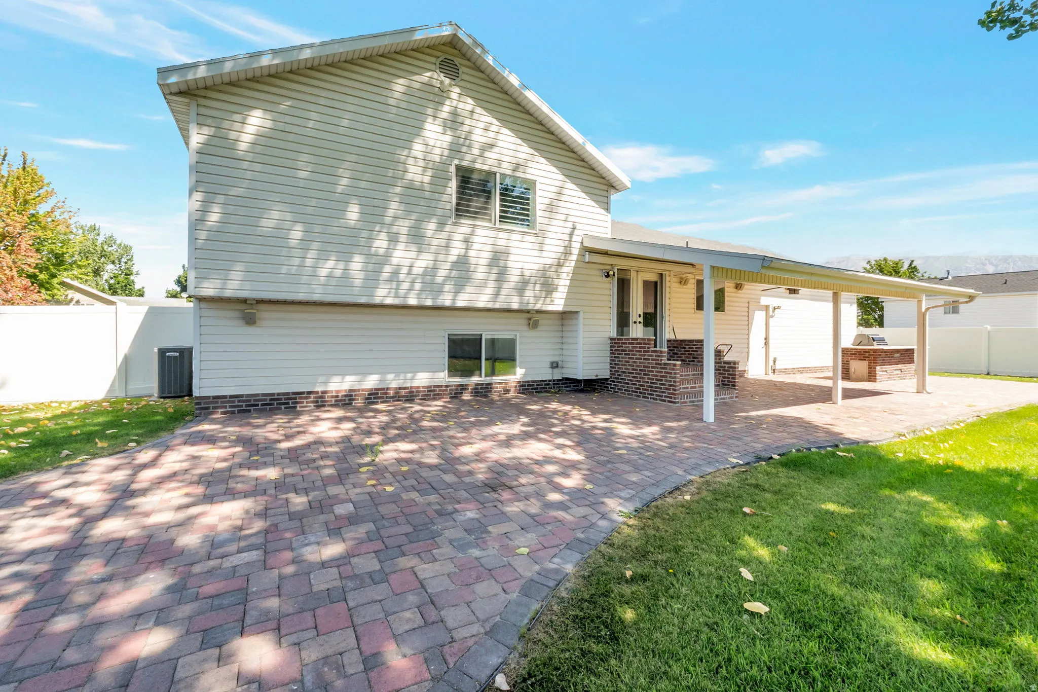 Expansive paver patio with a covered outdoor living area and built-in outdoor kitchen