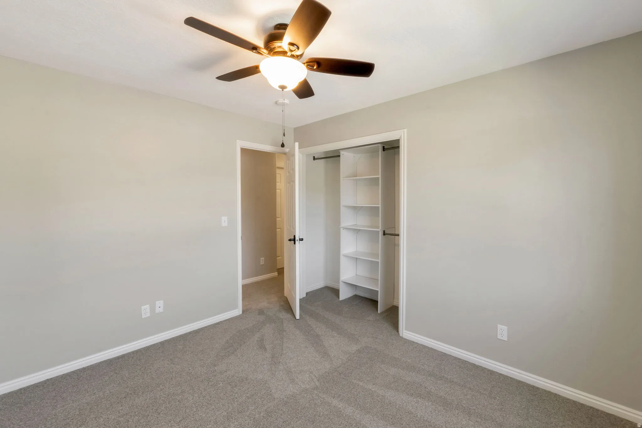 Room featuring neutral grey carpet, light grey painted walls, and white baseboards