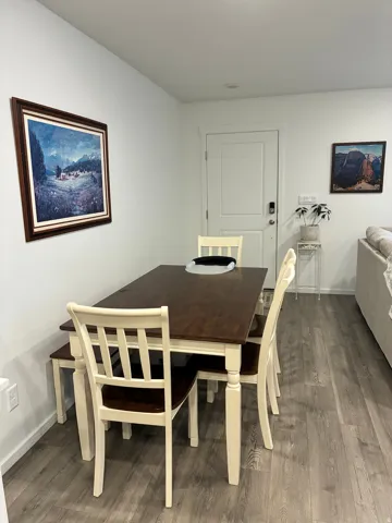 Dining area featuring wood-finish flooring, white walls, and a recessed ceiling light