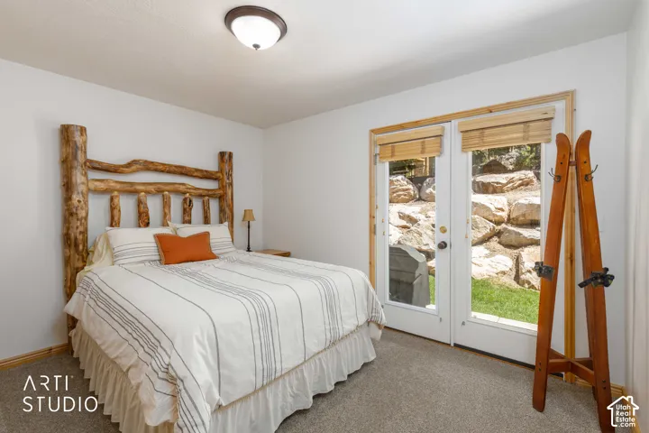 French doors with wood-finish trim and integrated shades open to outdoor patio  with Grill and deck space.