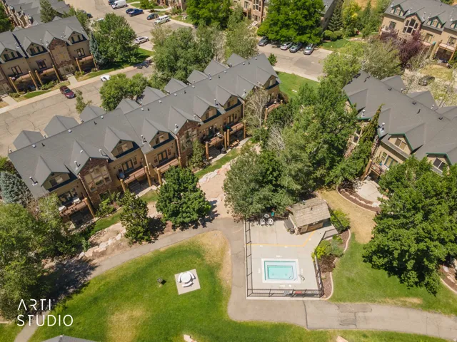 Behind Bldg 11 is a community hot tub with surrounding lounge area, nestled within mature trees and manicured green spaces