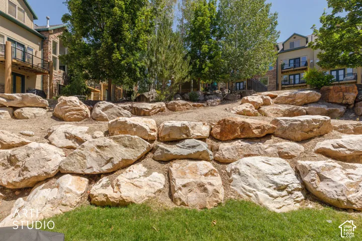 Rock retaining wall featuring large, natural stone boulders and pathway to jacuzzi