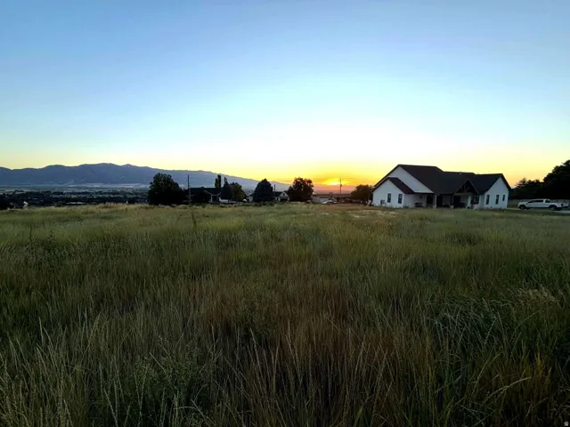Expansive open terrain featuring a mountain backdrop and distant city lights