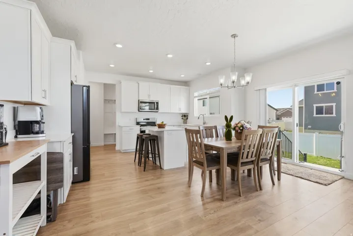 Open-concept kitchen and dining area featuring light wood-finish flooring