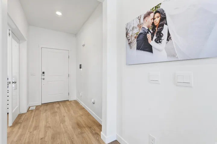 Entryway featuring wood-finish flooring, a contemporary white door, recessed lighting, and crisp white walls