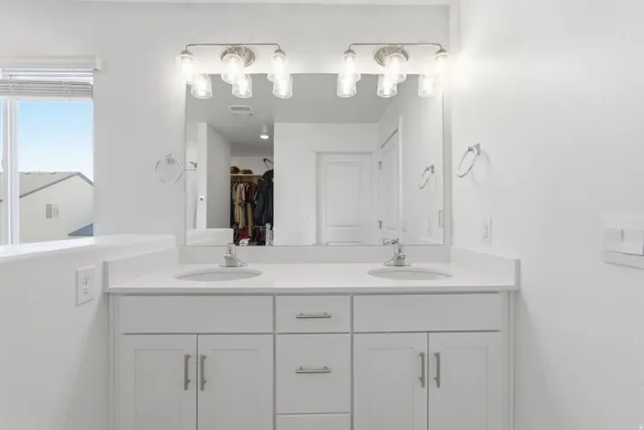 Double vanity featuring white cabinetry, undermount sinks, and a light-toned countertop