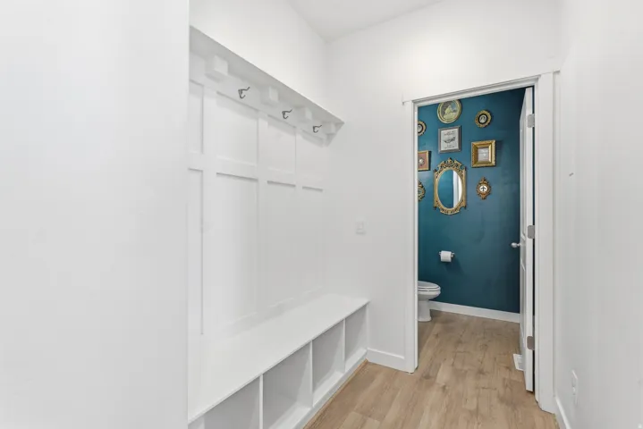 Entryway featuring a built-in bench with integrated cubbies and wall-mounted coat hooks