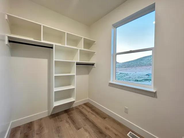 Built-in custom shelving and hanging rods in a neutral color palette