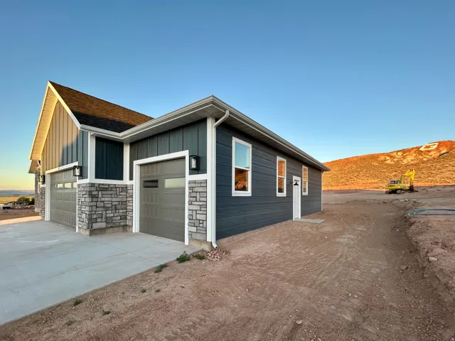 Contemporary exterior showcasing dark gray horizontal siding, stone veneer accents, and white trim