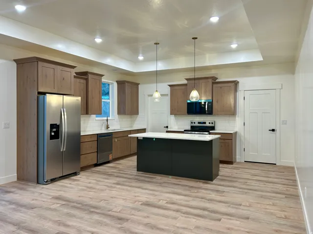 Kitchen featuring wood-finish flooring, recessed lighting, and a tray ceiling