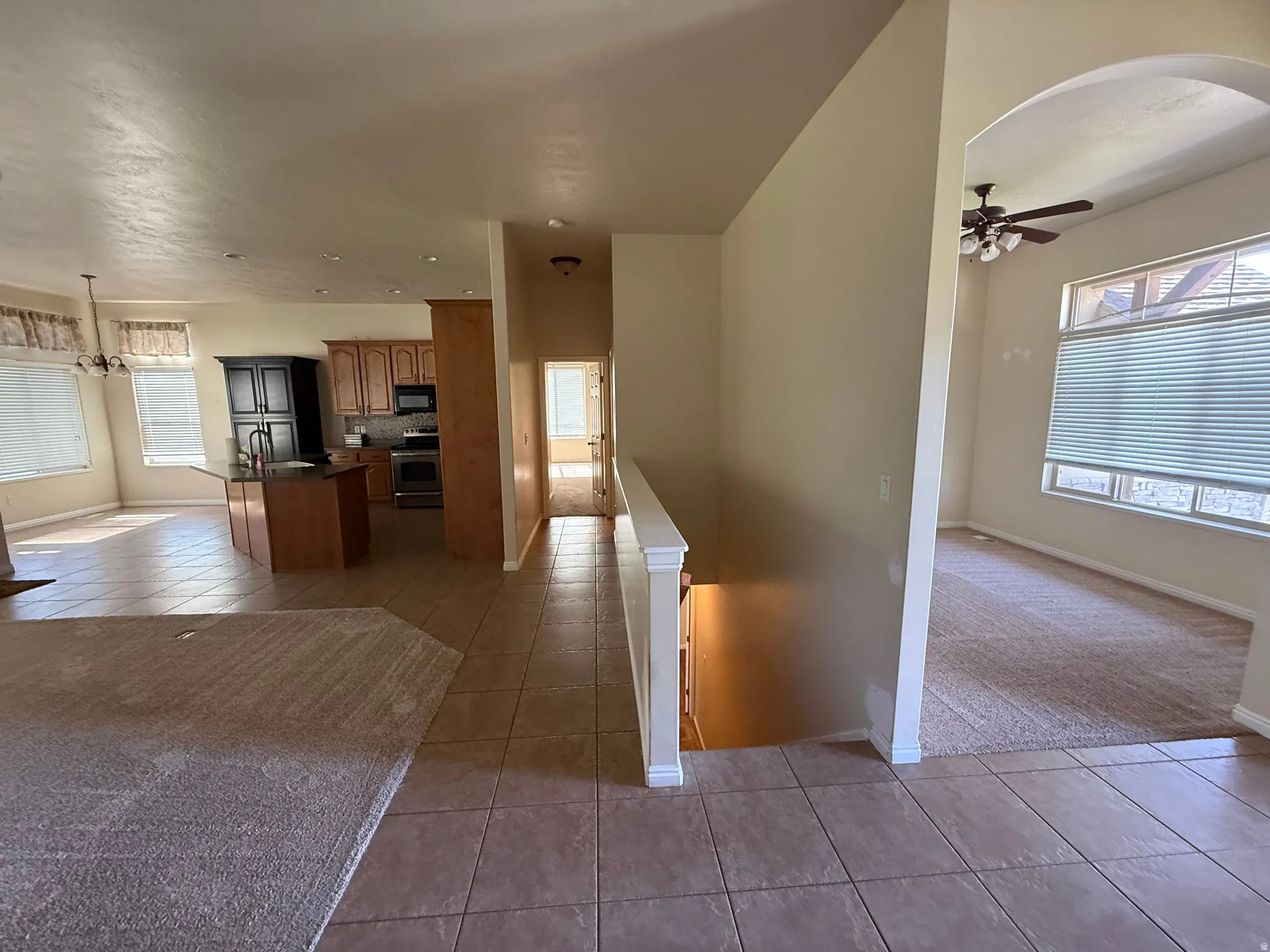 Open-concept living space with tile and carpet flooring