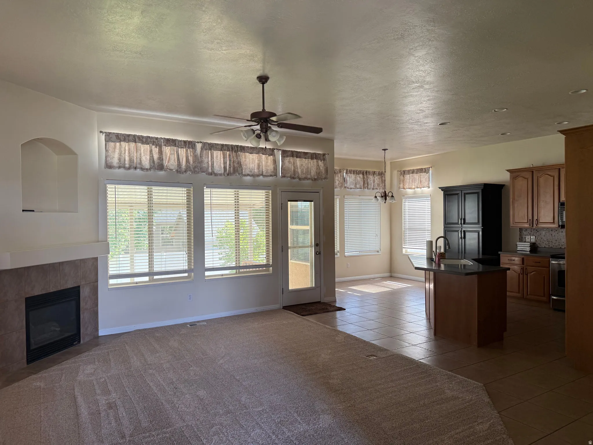 Spacious living area featuring a tiled fireplace and a built-in display niche