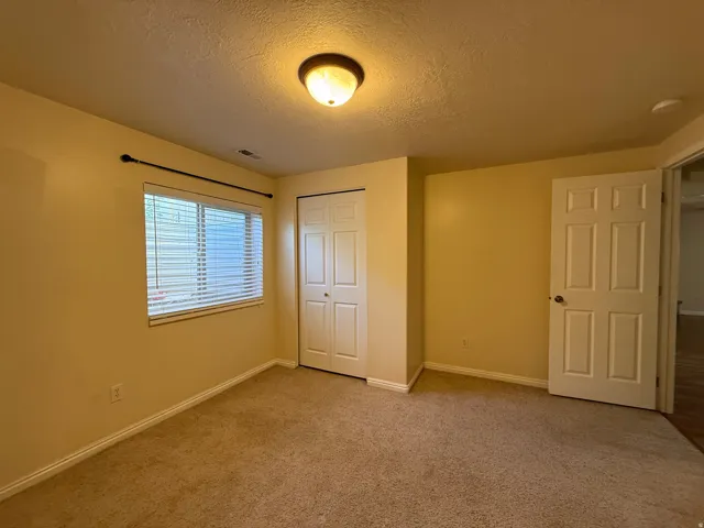 Carpeted flooring, window with blinds, bi-fold closet doors, and recessed ceiling lighting