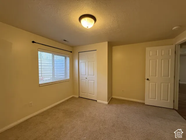 Carpeted flooring, window with blinds, bi-fold closet doors, and recessed ceiling lighting