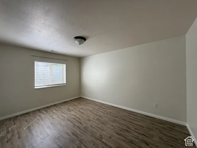 Neutral wall paint, wood-finish flooring, and window with blinds