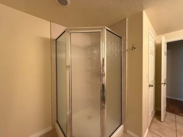 Corner shower enclosure with textured glass panels and a chrome frame
