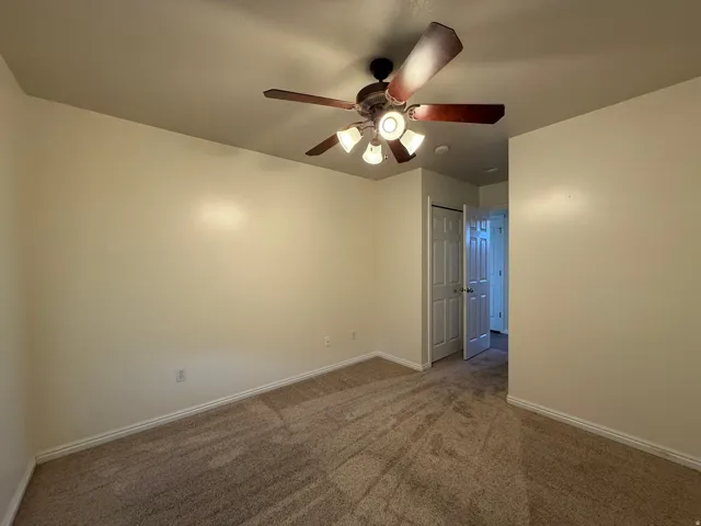 Neutral-toned walls complement the textured carpeting
