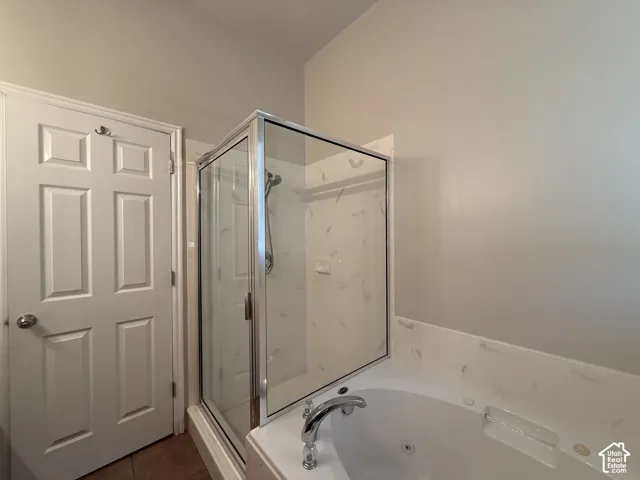 Shower enclosure with glass panels and a built-in bathtub with a deck-mounted faucet