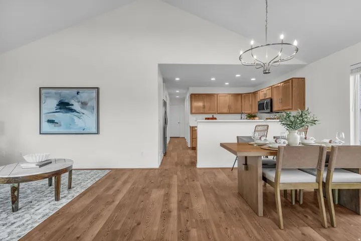 Open-concept living space featuring vaulted ceilings and wood-finish flooring