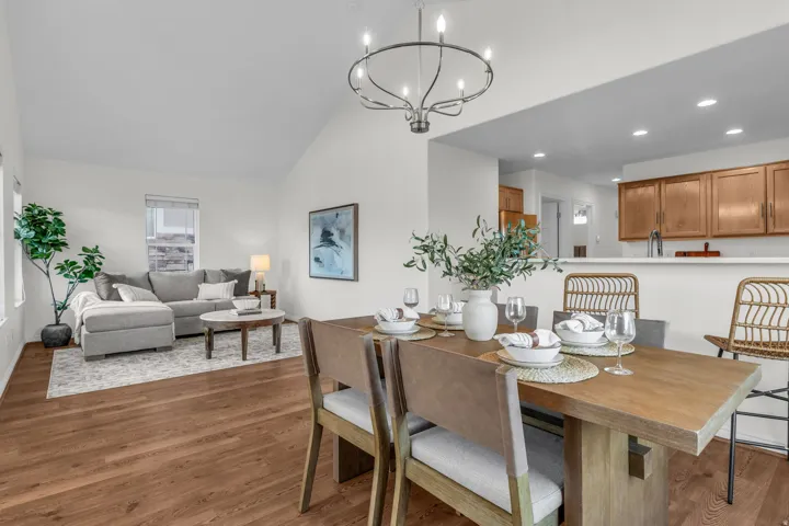 Dining area featuring a wood-finish table, a wrought iron chandelier, and wood-finish flooring