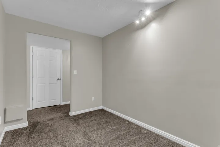 Interior room featuring light gray wall paint and dark gray carpet