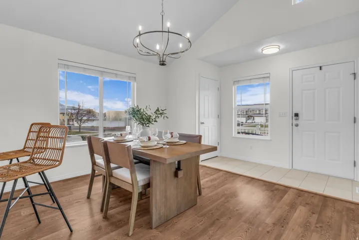 Dining area featuring wood-finish flooring and a contemporary chandelier