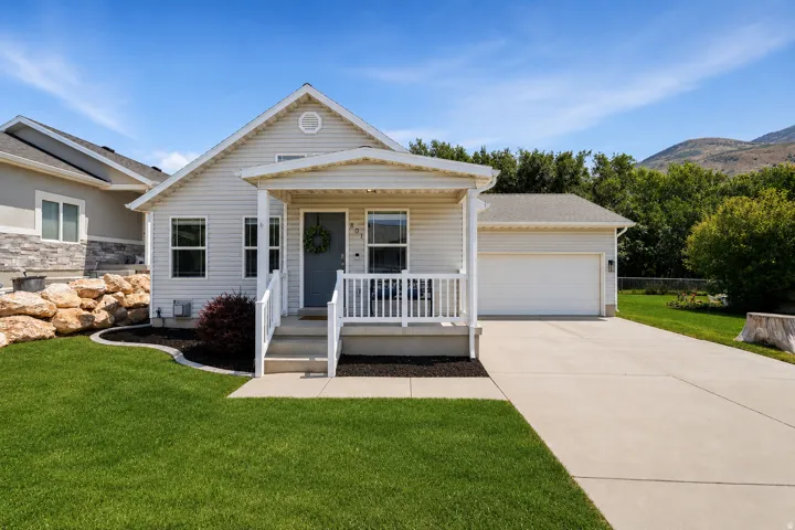 Single-story residence featuring light-colored siding and a covered front porch with white railings