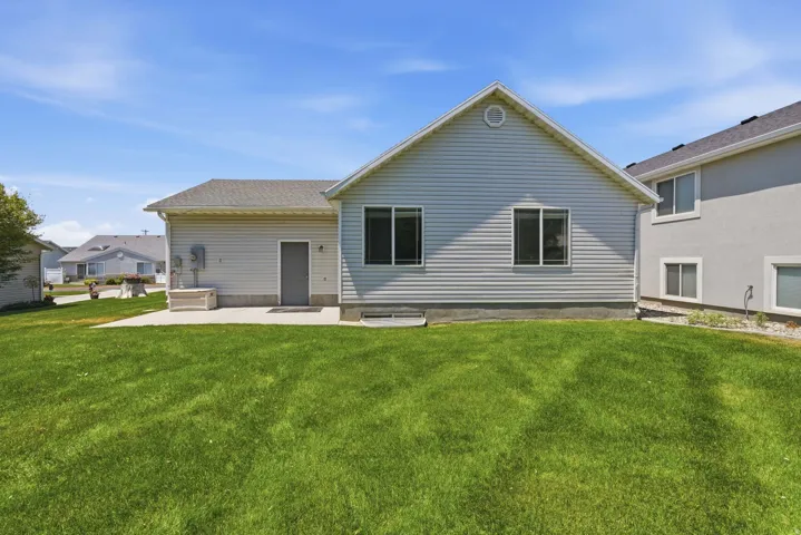 Expansive green lawn with a concrete patio
