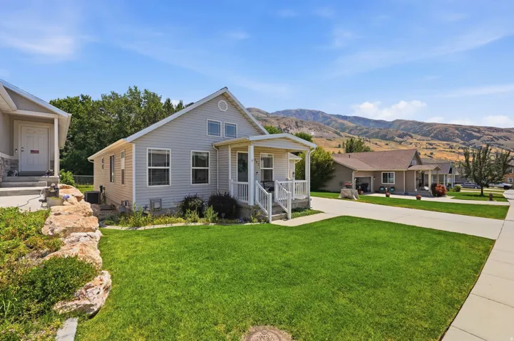 Light gray siding exterior with a covered front porch featuring white railings