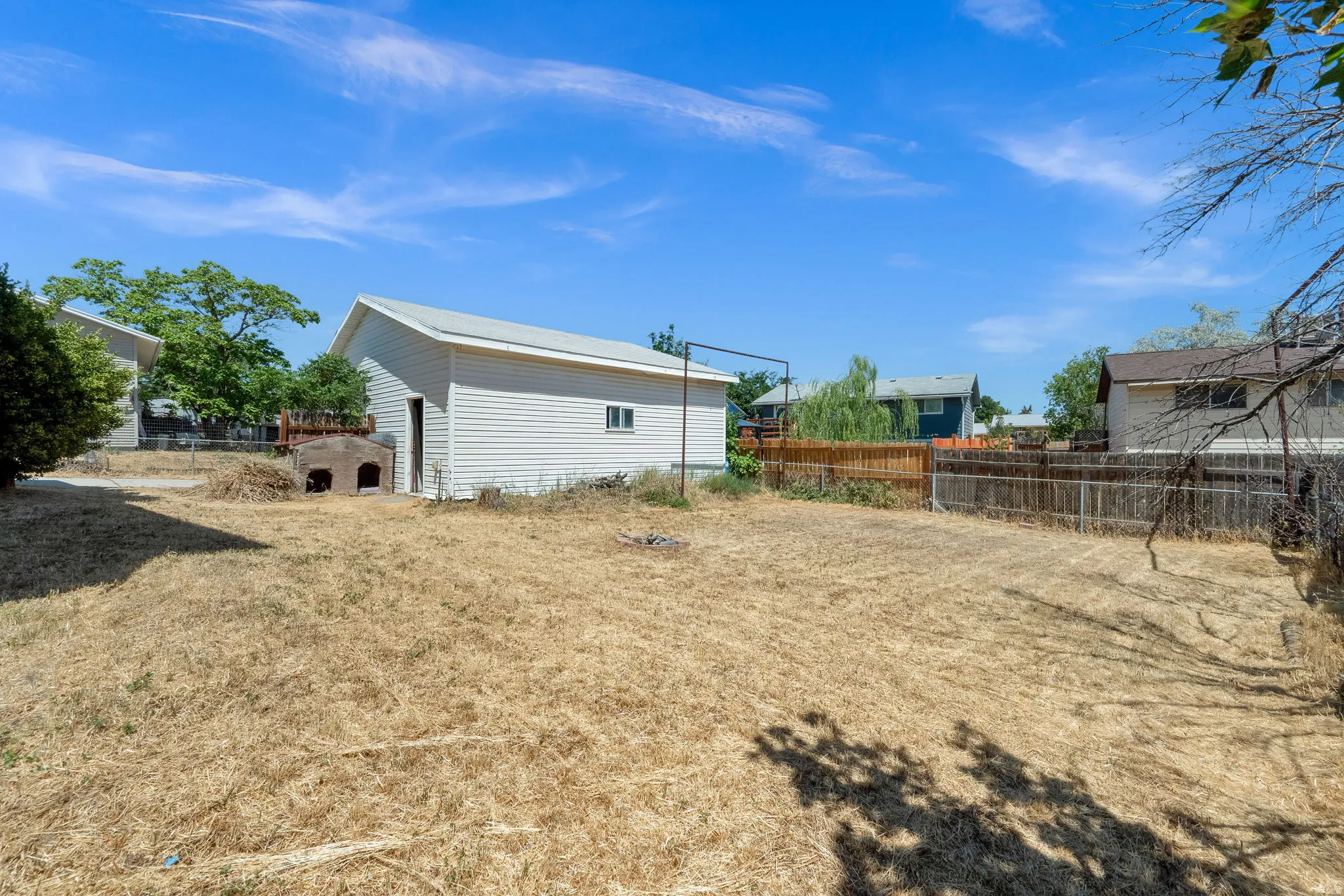 Spacious backyard with a detached storage building featuring white siding and a sloped roof