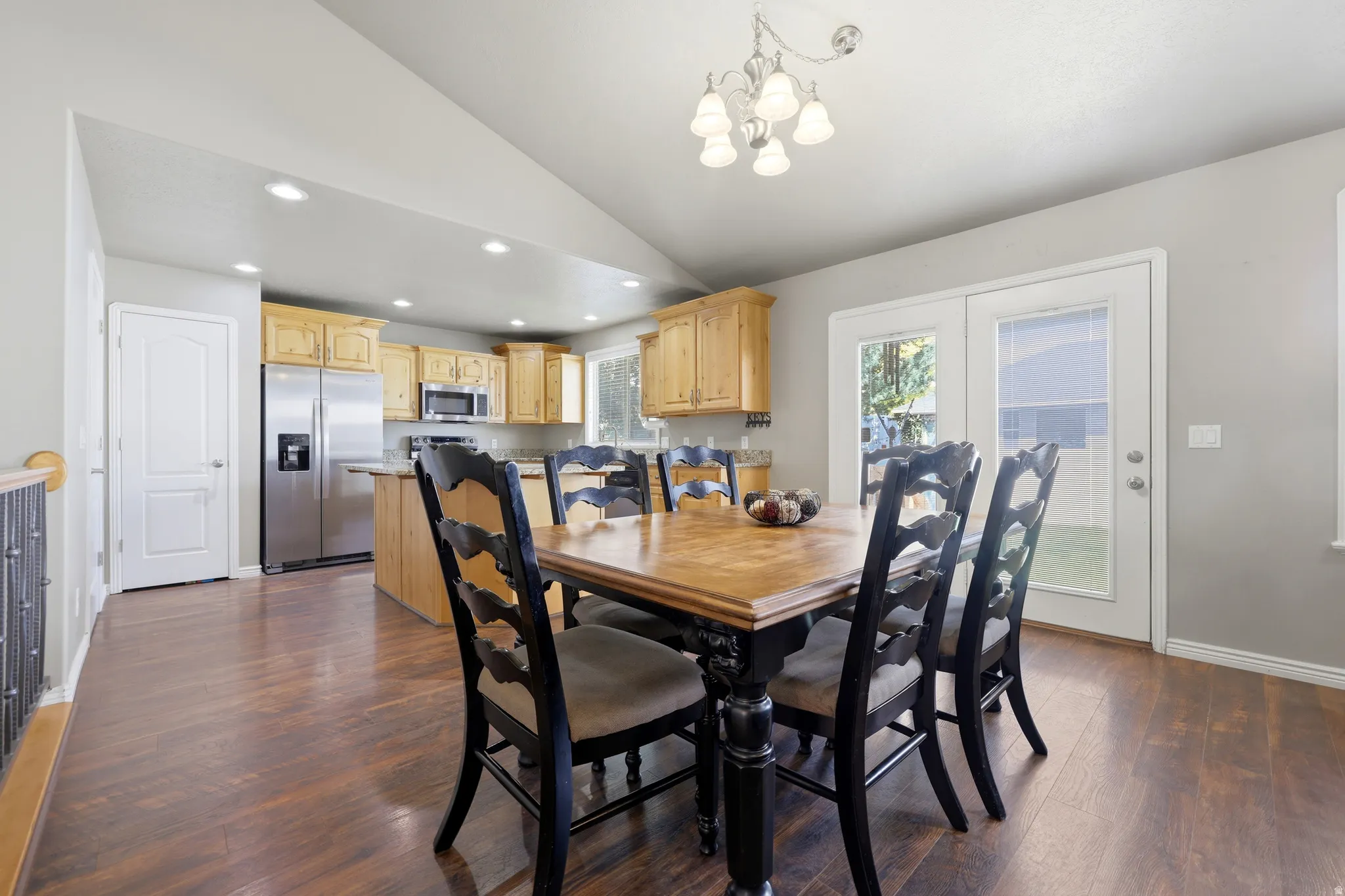 Vaulted ceiling over dining area with wood-finish flooring