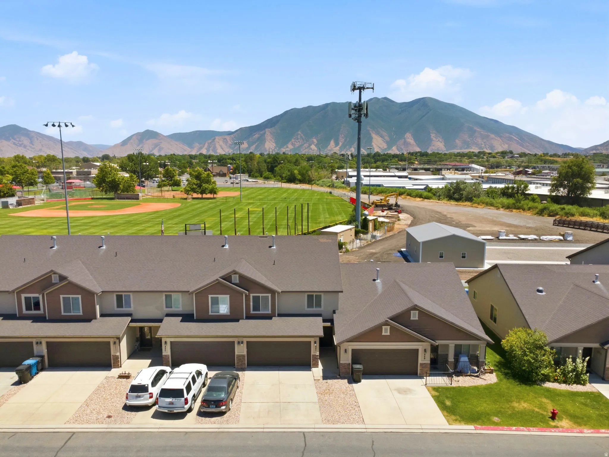 Modern multi-unit residential property featuring a distinctive brown and tan exterior with attached garages and paved driveways