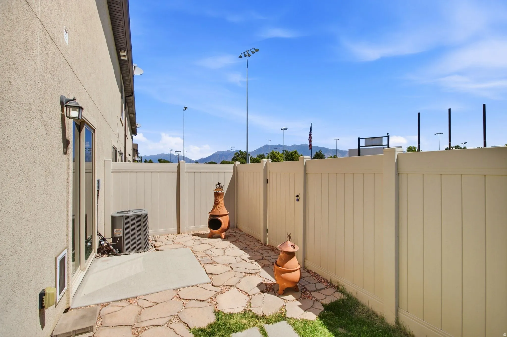 Private patio area featuring a concrete pad and flagstone pathway
