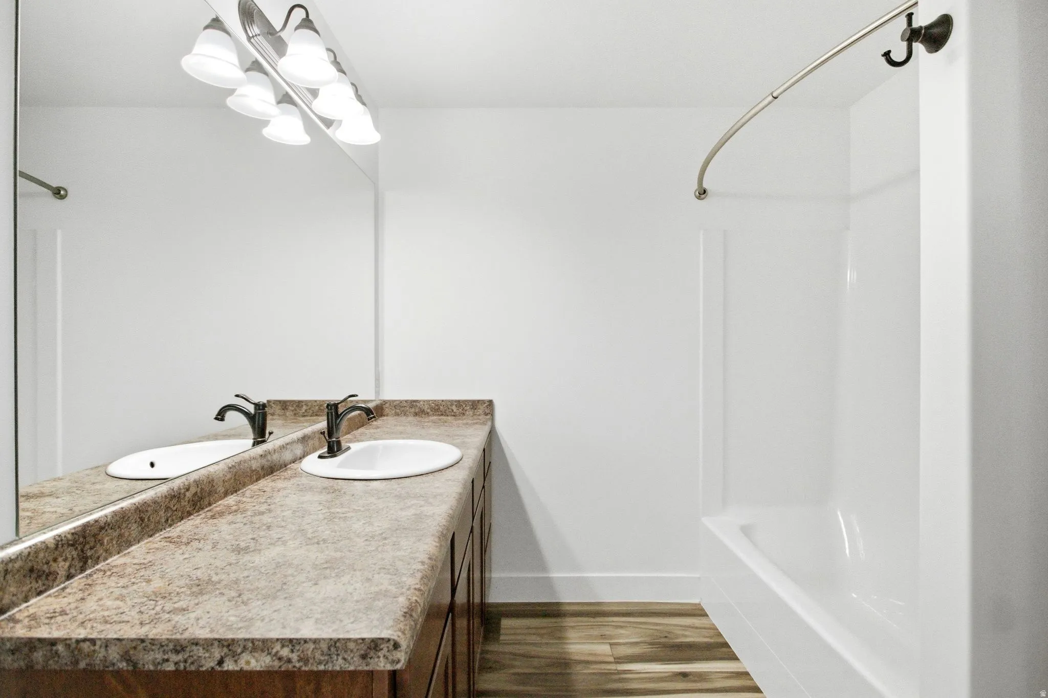 Bathroom featuring a double vanity with an integrated countertop, undermount sinks, and dark bronze-finish faucets