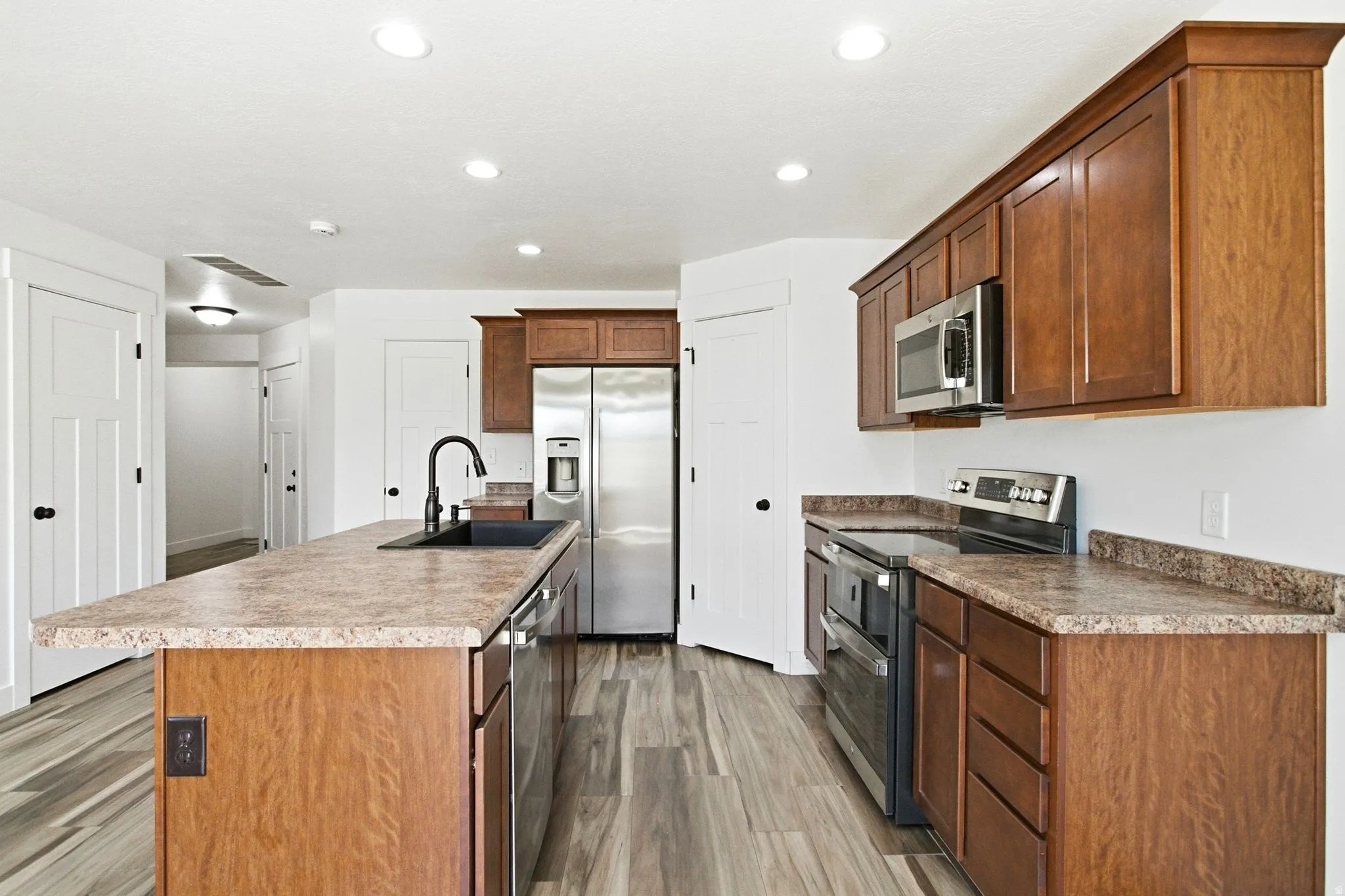 Contemporary kitchen featuring wood-finish flooring and white walls