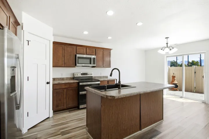 Kitchen featuring wood-finish flooring, recessed lighting, and a center island with sink
