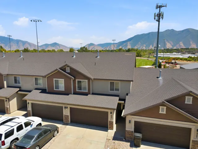 Townhome exteriors featuring two-tone siding, attached garages, and a mountain backdrop