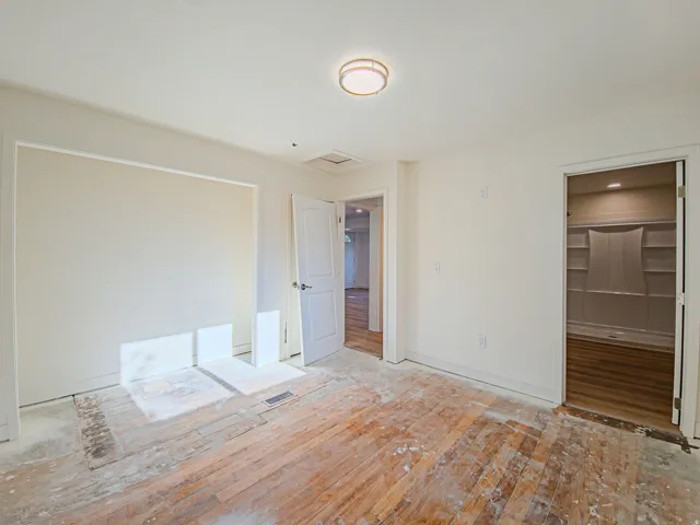 Recessed closet with built-in shelving, wood-finish flooring, and a flush-mount ceiling light, new carpet on the way!