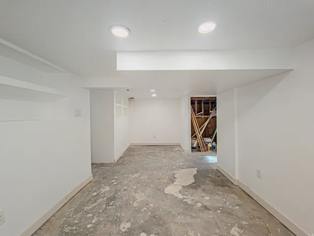 White painted walls with recessed lighting, new carpet on the way! Laundry room in background.