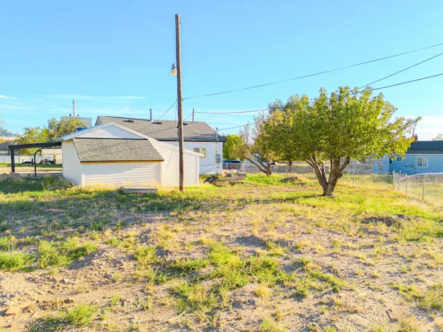 Detached shed with white siding and a gray shingle roof
